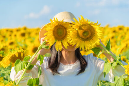 Portrait of happy Asian woman enjoying and relaxing in a full bloom sunflower field during travel holidays vacation trip outdoors at natural garden park at noon in Lopburi, Thailand. Lifestyle. 初めての方へ|阿波座の婦人科 おのうえレディースクリニック